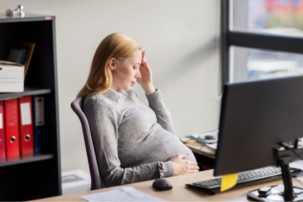 young pregnant woman stressed at work