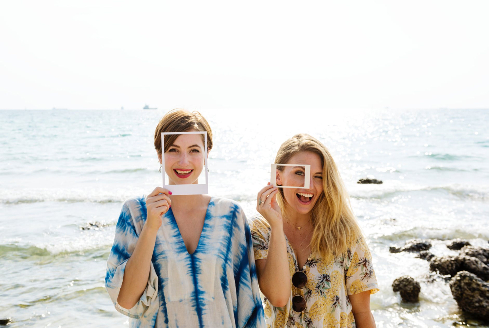 Two women smiling by the ocean